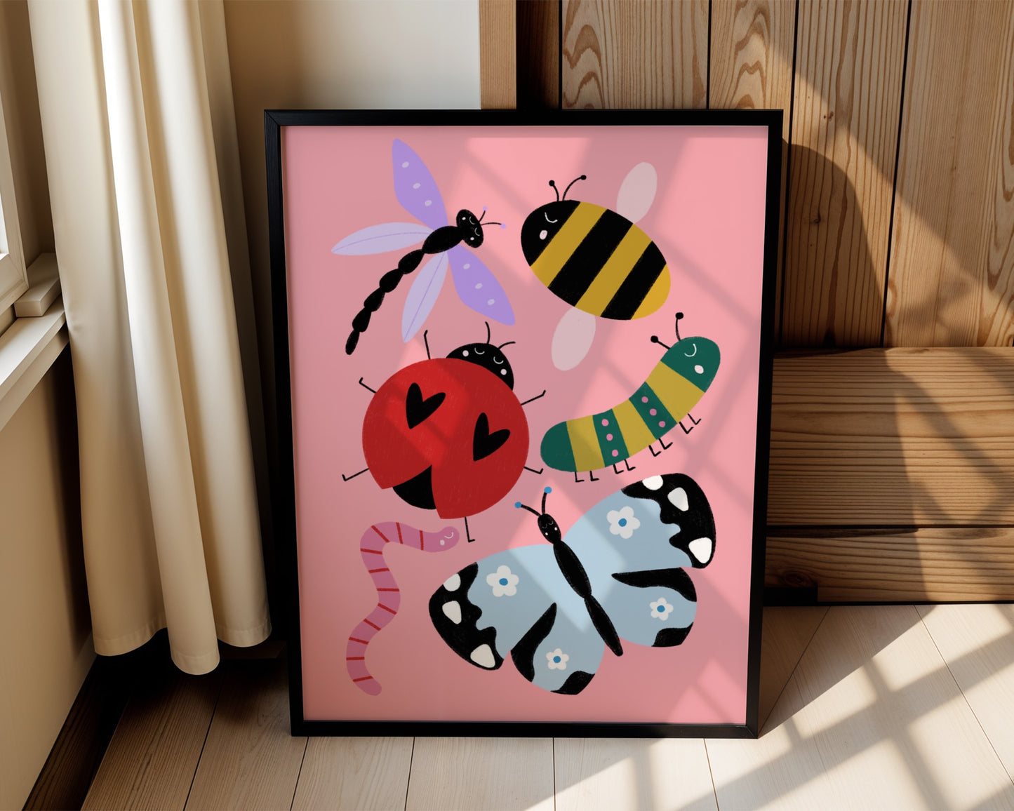 Kids wall art with pink background featuring bug illustrations of a pink and red worm, a blue butterfly, a red ladybird, a green and pink caterpillar, a bee and a purple dragonfly, all with cute faces.
