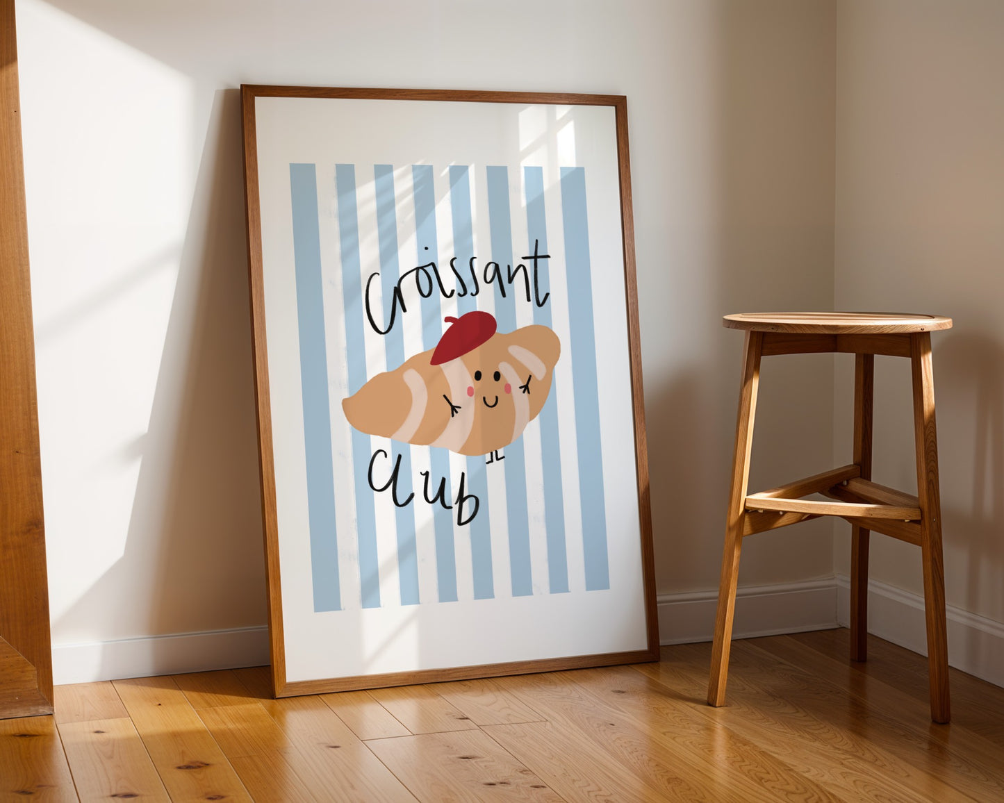 Cute kids wall art featuring striped background and a smiling croissant in a beret with the phrase croissant club in playful Lettering, perfect for nursery or playroom decor