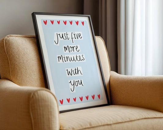 Framed picture with 'Just five more minutes with you' text on a beige couch.
