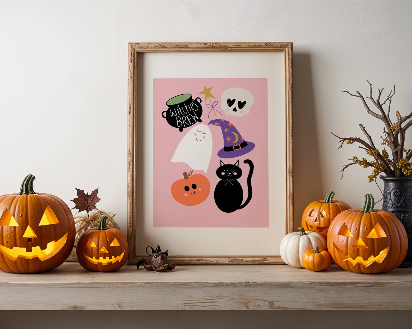 Halloween-themed decor with framed artwork, pumpkins, and a black cat figurine on a wooden surface.