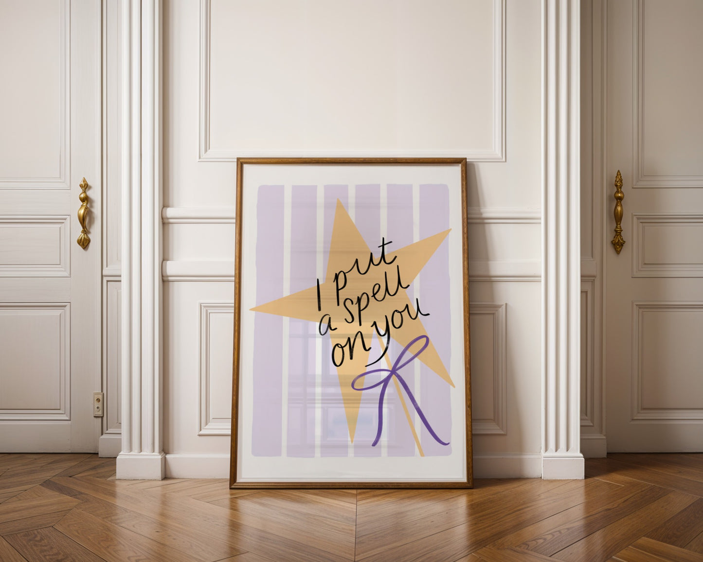 Framed artwork with a star design and text on a wall in a room with wooden flooring.