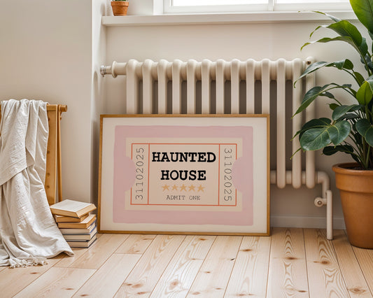Framed 'Haunted House' sign on a wooden floor with a radiator and plant in the background