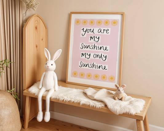 Wooden shelf with plush rabbit toys and a framed quote on a beige wall.