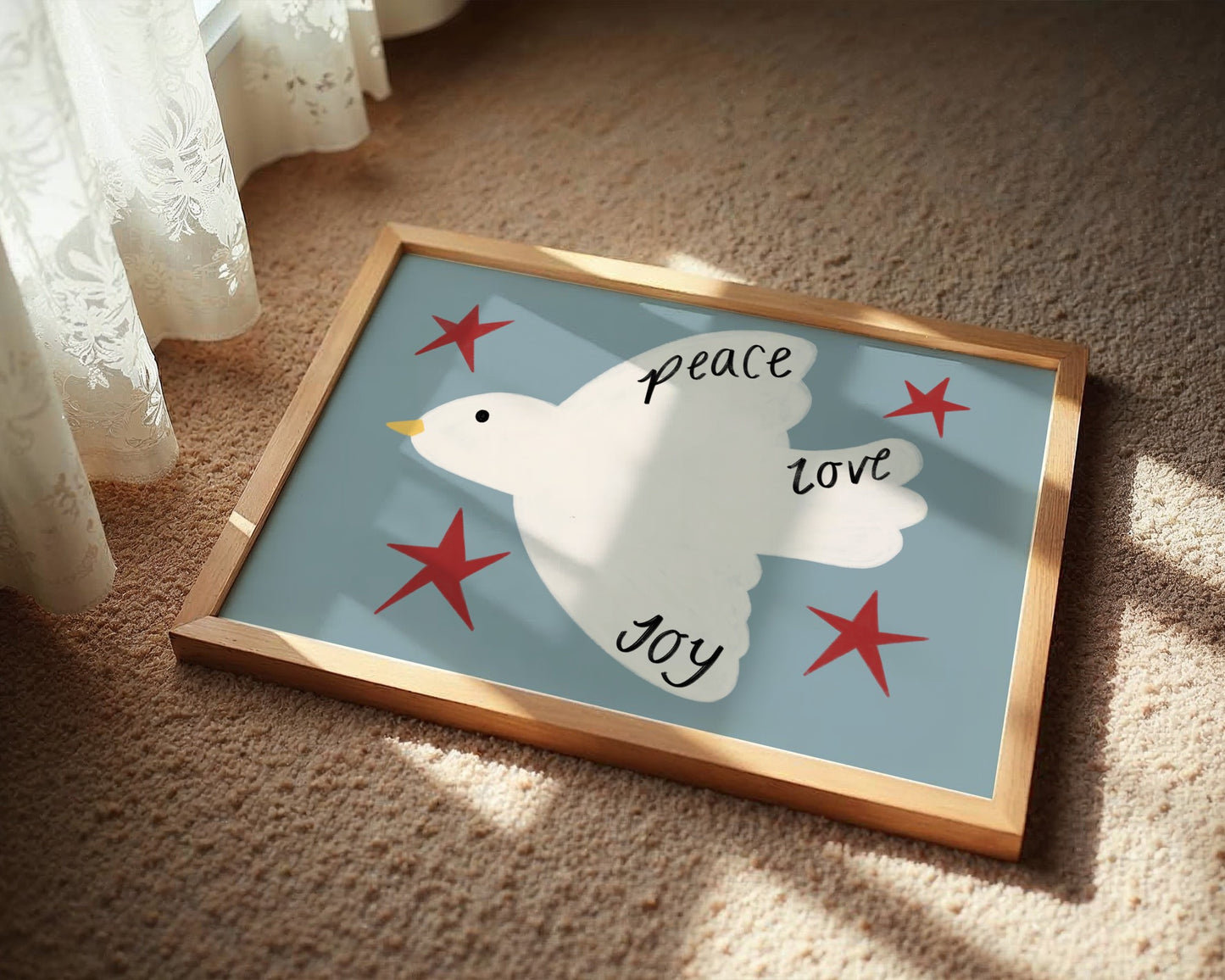 Framed artwork with a dove and text on a blue background, placed on a carpeted floor.