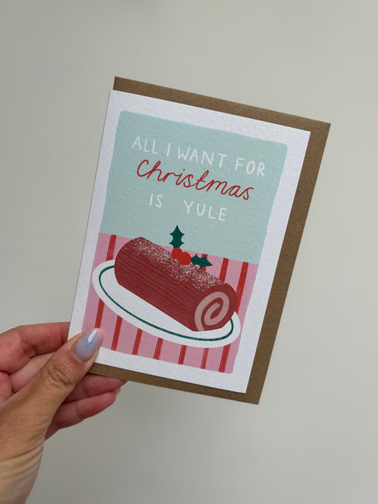 Card with Christmas-themed design and text held by a hand against a plain background