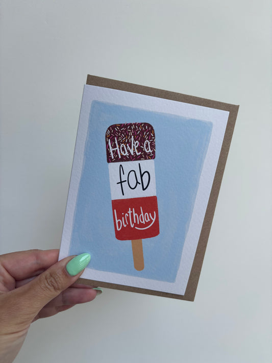 A6 premium textured recyclable greeting card with white border, blue background and a FAB ice lolly with the words “ have a fab birthday” in handwritten text. Brown Kraft envelope included.