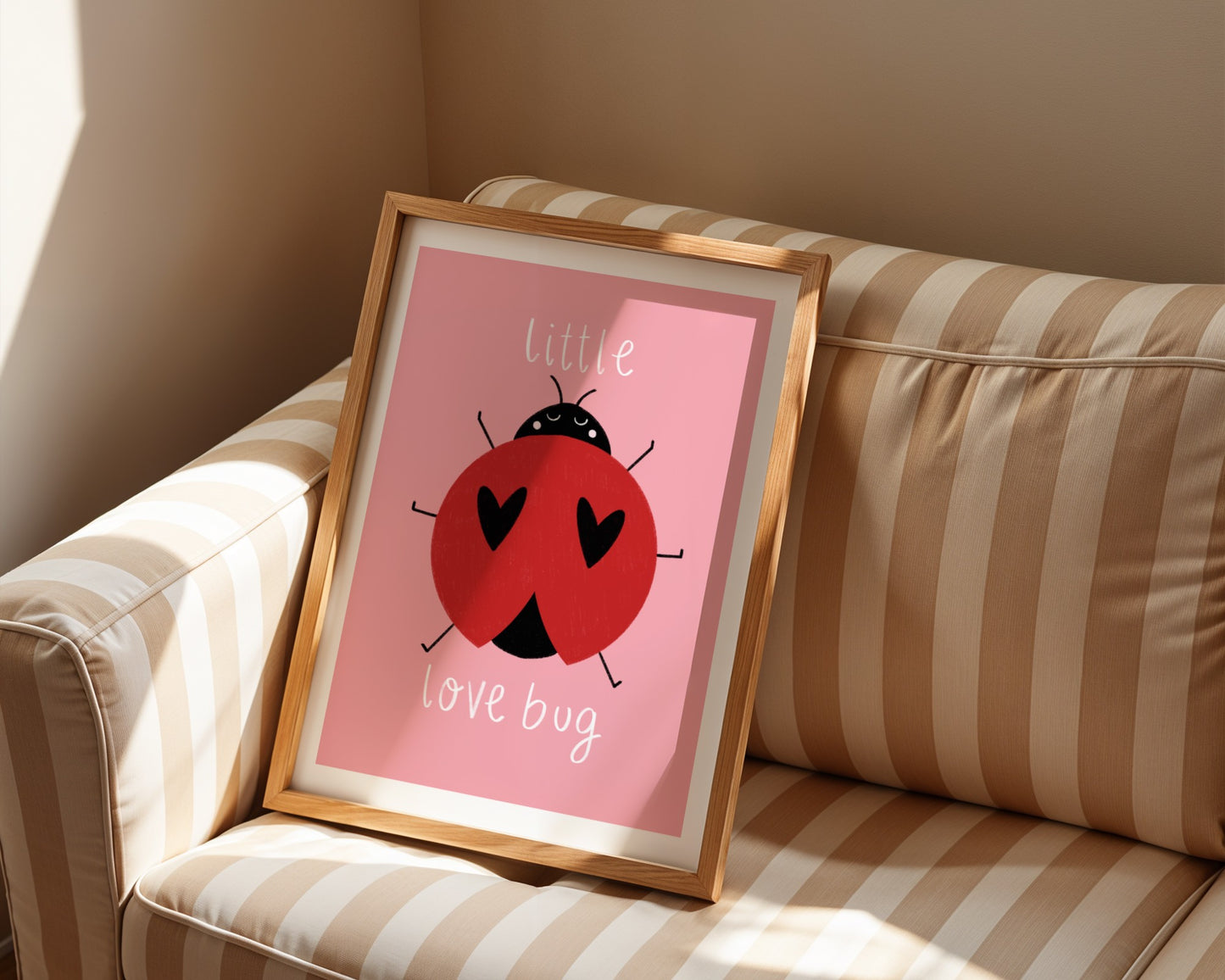 Kids wall art with pink background, a hand drawn illustration of a ladybird with face and the words “little love bug” In white handwritten text.