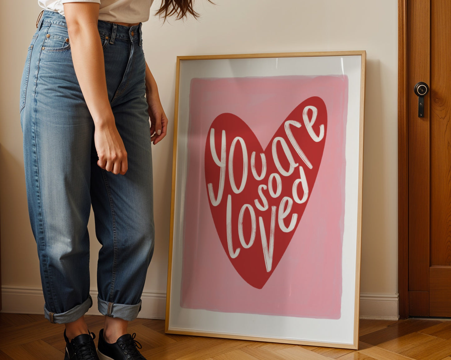 Kids wall art with pink background a red heart illustration featuring “you are so loved” quote