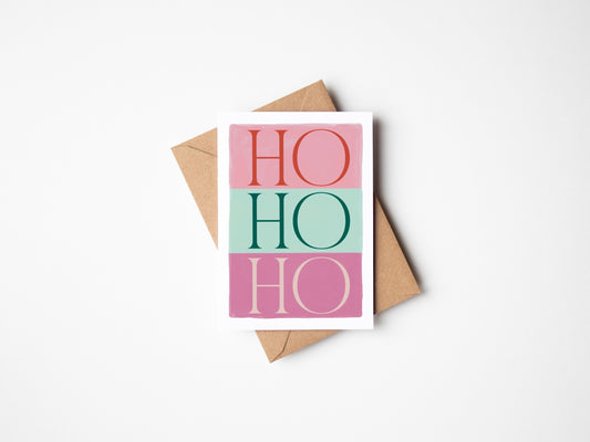 Greeting card with 'HO HO HO' text in pink, red, and green on a white background