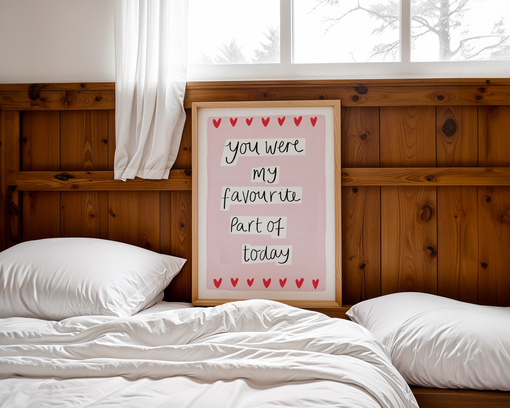 Bedroom with a wooden headboard, white pillows, and a framed quote on a pink background.