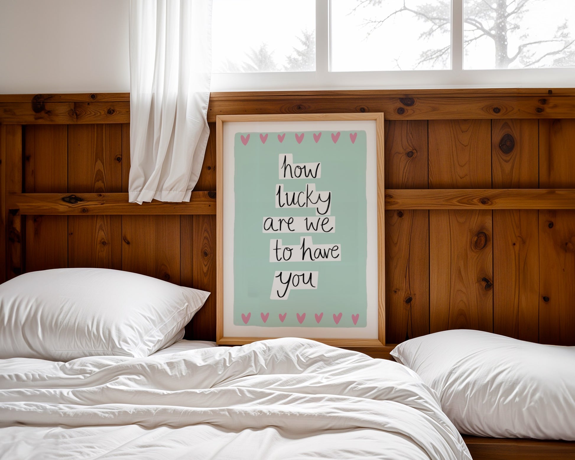 Framed quote above a bed with wooden headboard and white pillows