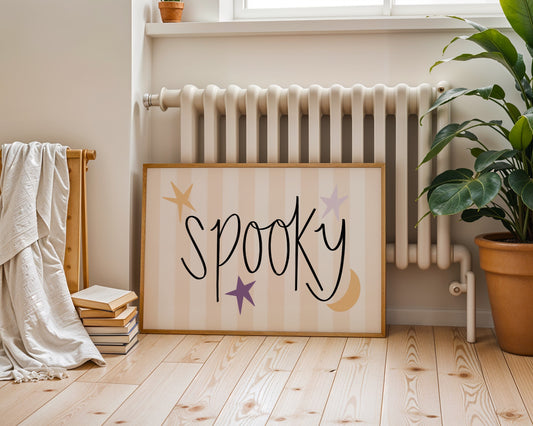 Framed sign with 'Spooky' text in a room with a radiator and plant