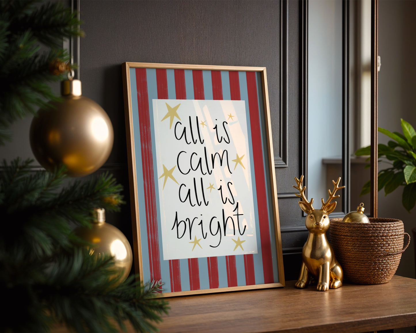 Framed artwork with 'all is calm, all is bright' text on a striped background, surrounded by festive decor.