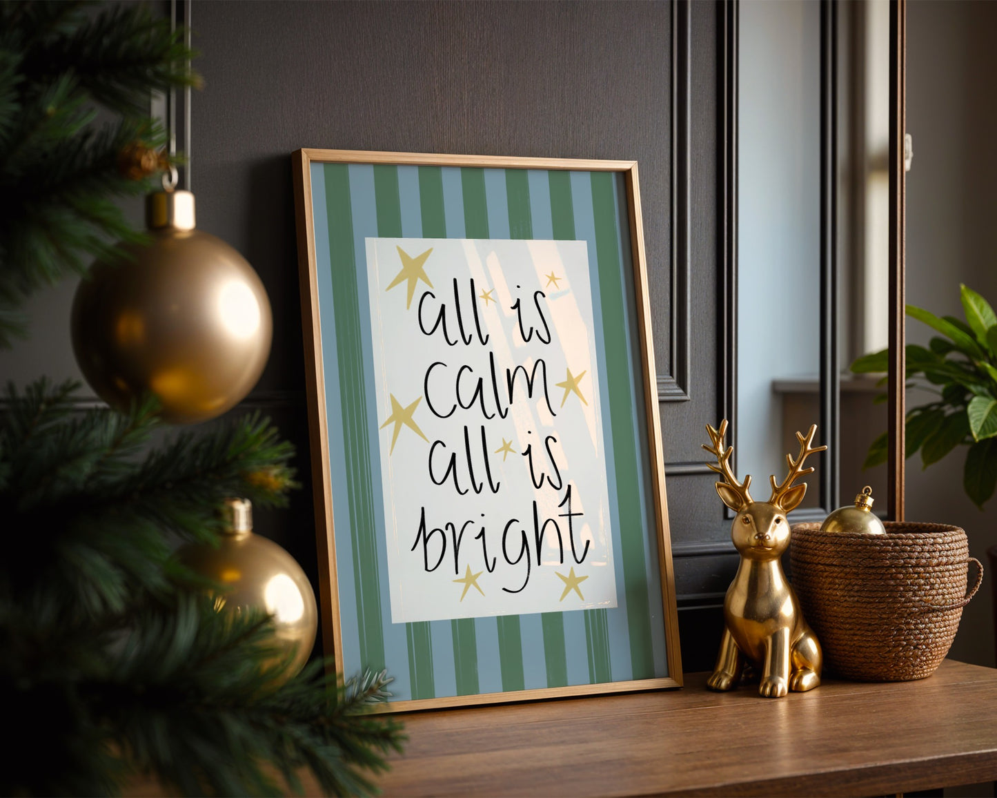 Framed Christmas-themed print with decorative items on a table.