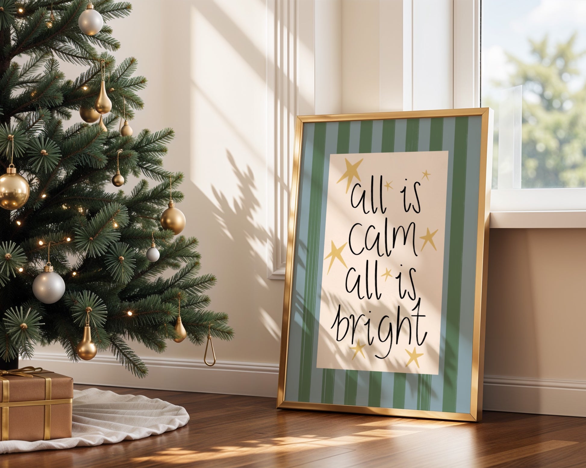Decorative Christmas tree with gold ornaments next to a framed print with 'All is calm, all is bright' text.