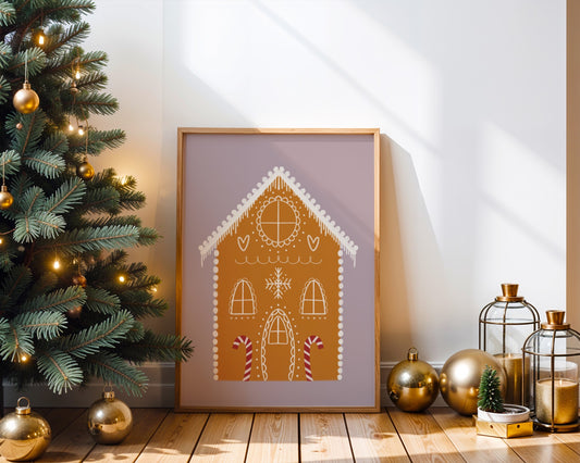 Framed gingerbread house art on a wooden floor with Christmas decorations.