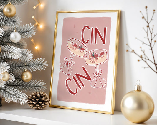 Framed artwork with 'CIN CIN' text and cocktail graphics on a shelf with Christmas decorations.