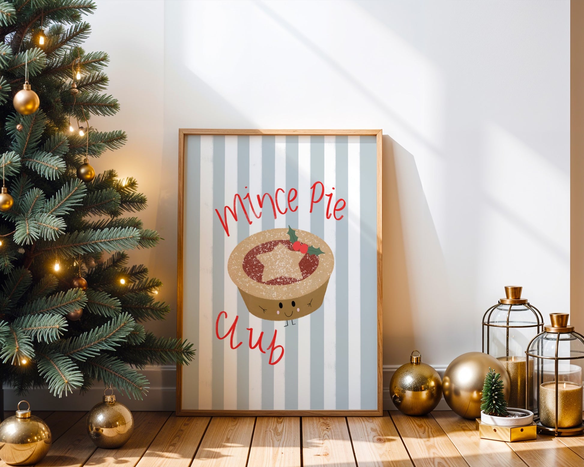 Framed Christmas poster with mince pie design next to a decorated Christmas tree.
