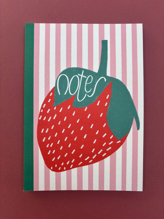 A5 lined notebook with pink and white stripes and large strawberry detail with green binding and word “notes”