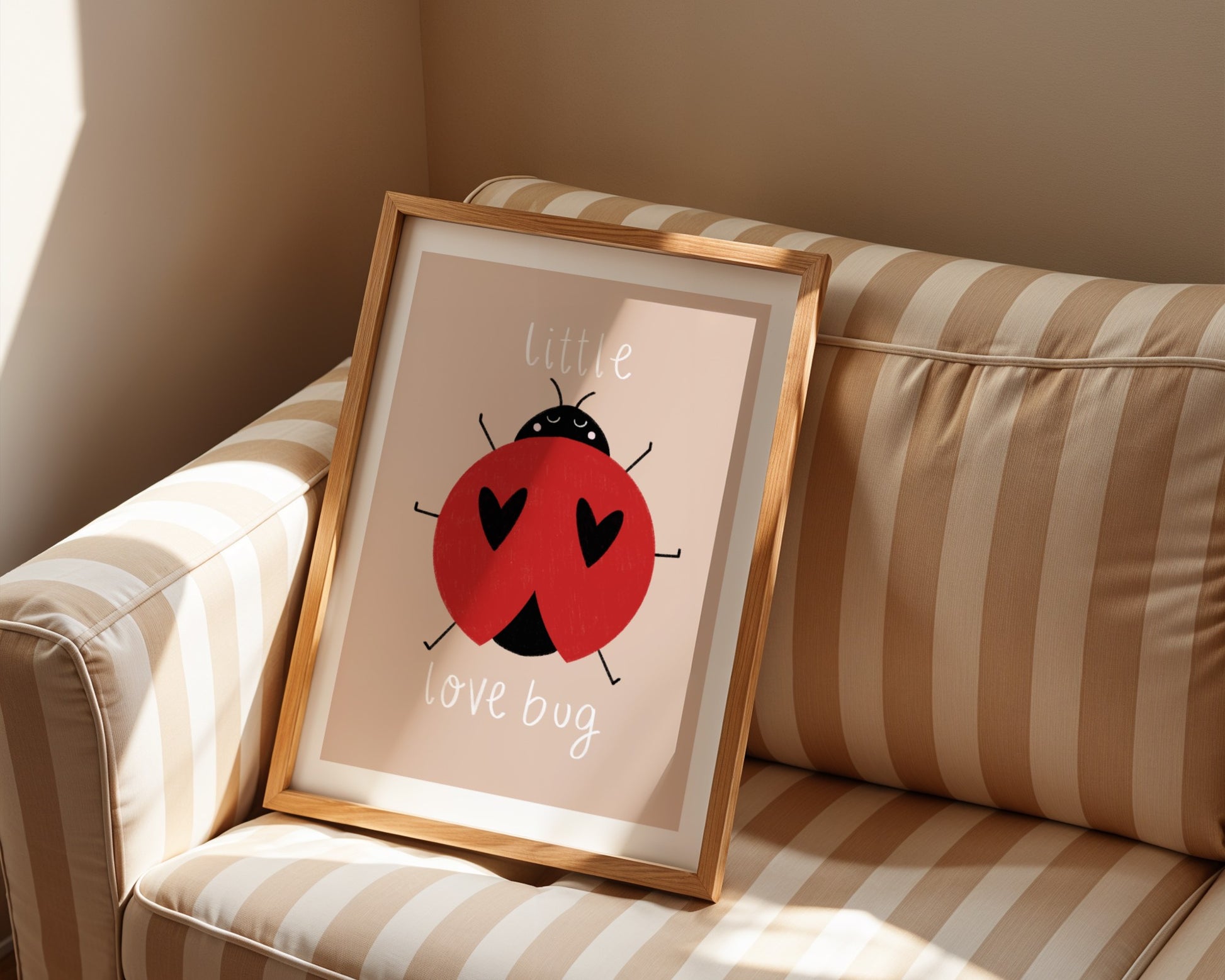Kids wall art with beige background,  a hand drawn illustration of a ladybird with face and the words “little love bug” In white handwritten text.