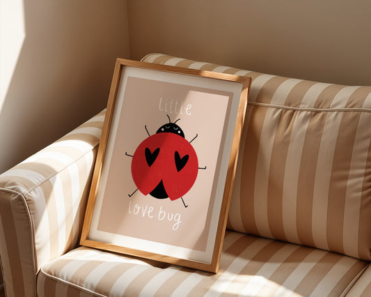 Kids wall art with beige background,  a hand drawn illustration of a ladybird with face and the words “little love bug” In white handwritten text.