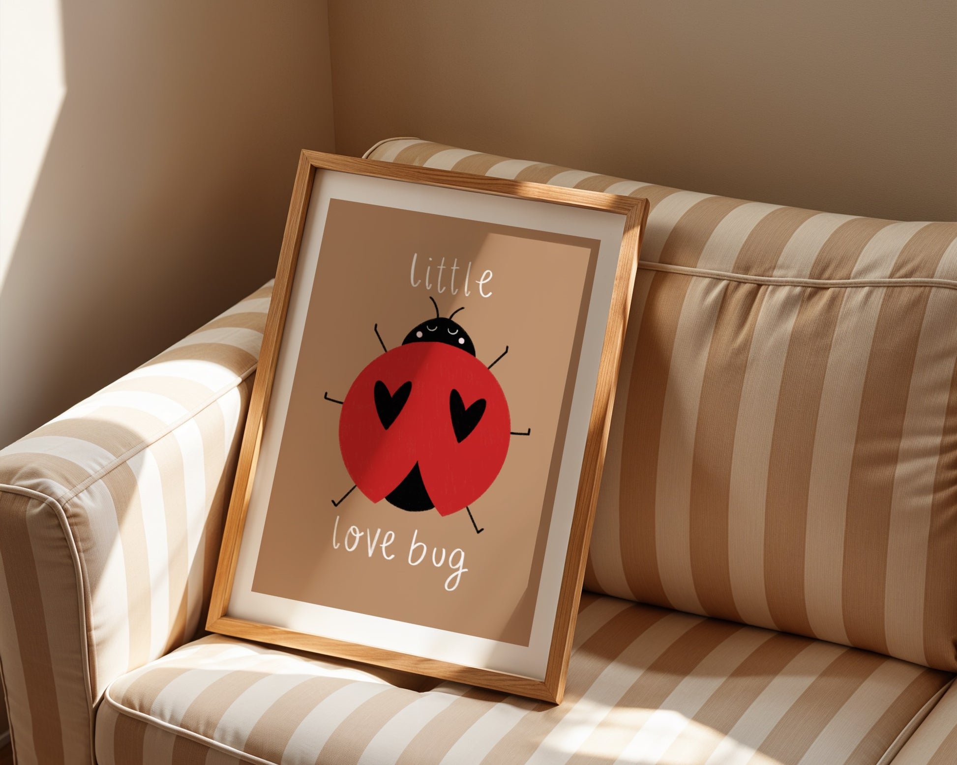 Kids wall art with brown background,  a hand drawn illustration of a ladybird with face and the words “little love bug” In white handwritten text.