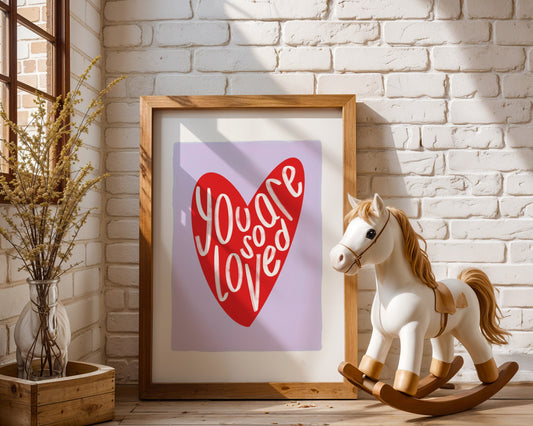 Kids wall art with lilac background a red heart illustration featuring “you are so loved” quote
